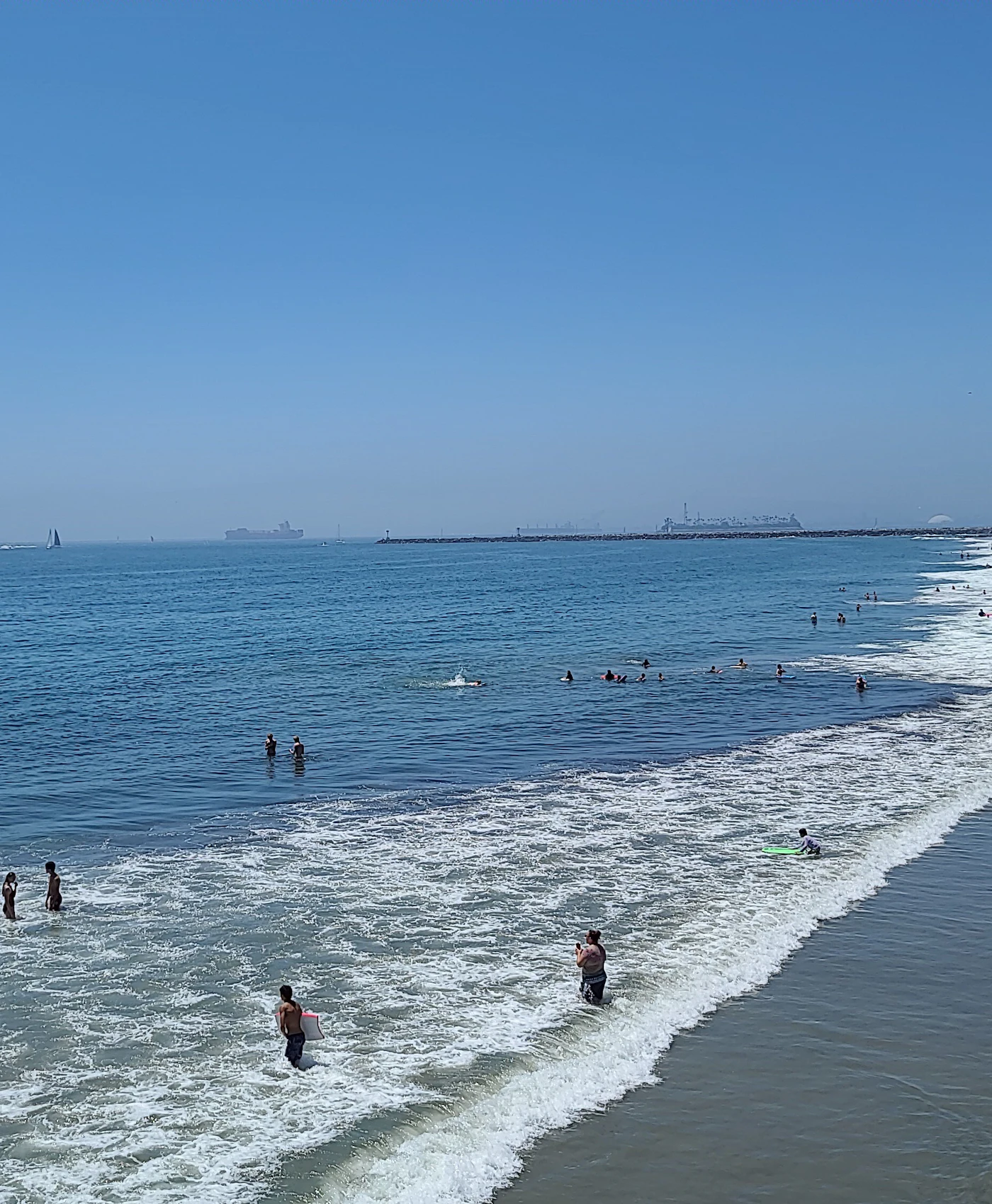 Swimmers and surfers along the Seal Beach shoreline