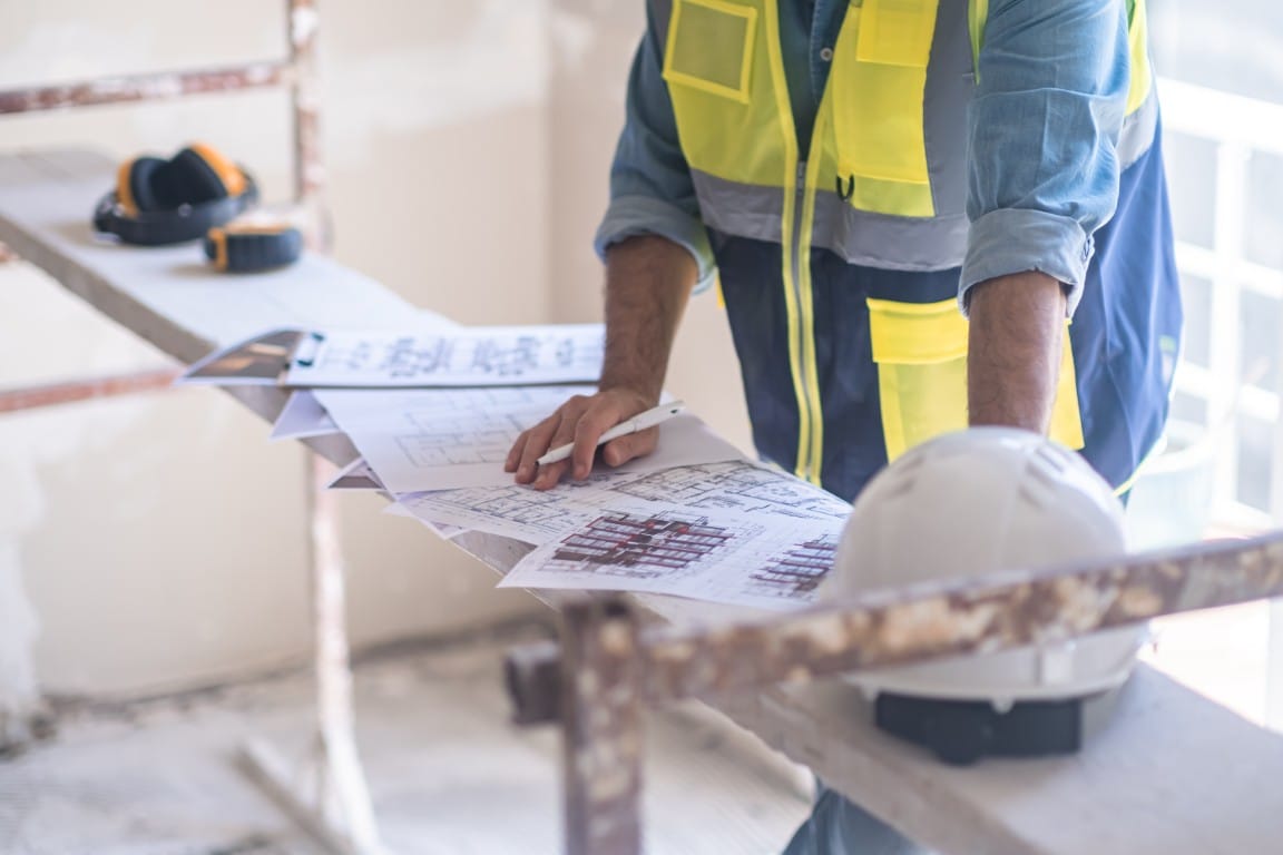 Contractor reviewing blueprints and project plans for a home renovation