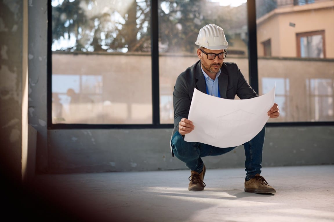 Contractor planning a project with blueprints and scheduling tools