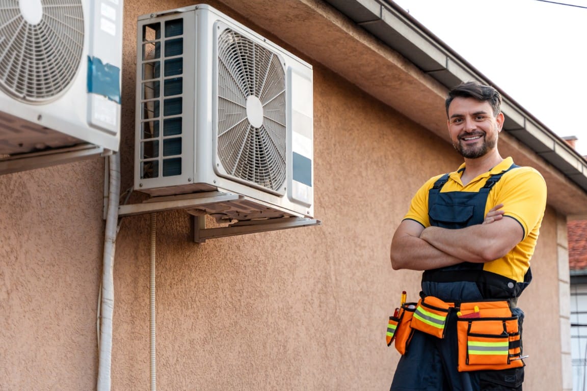 HVAC technician performing AC maintenance on a residential unit