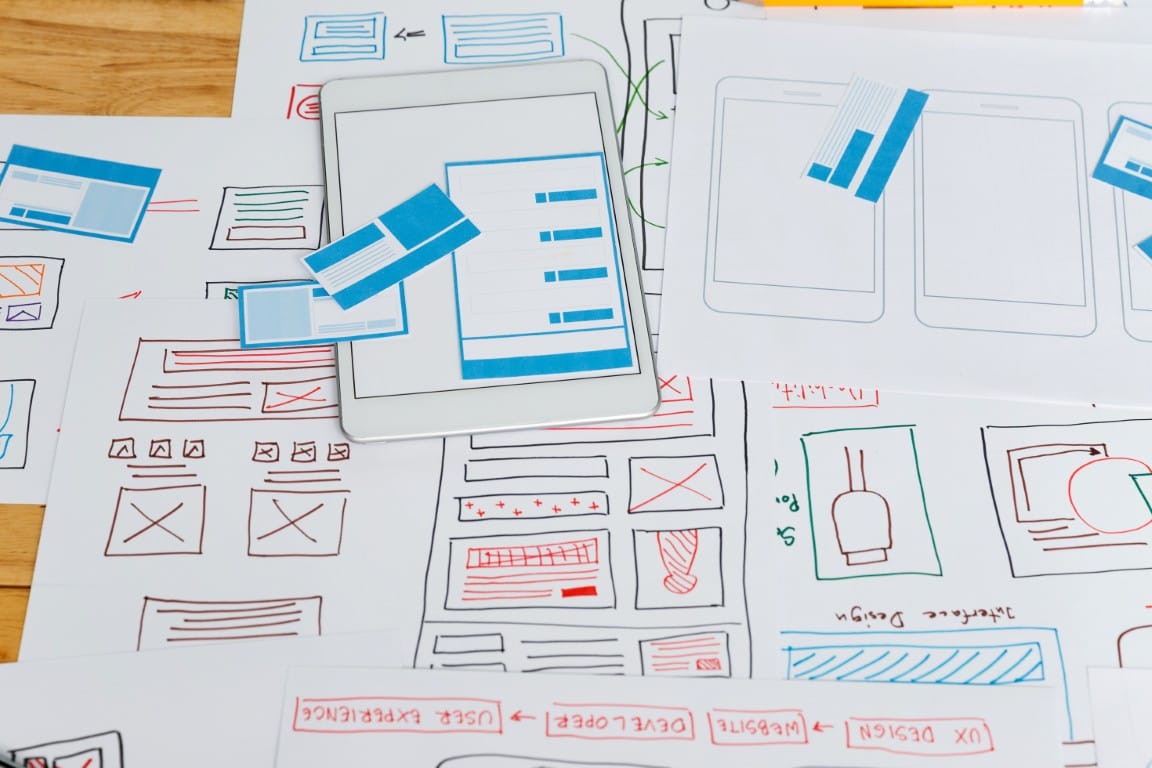 UX designer workspace with sketches and design tools for website planning