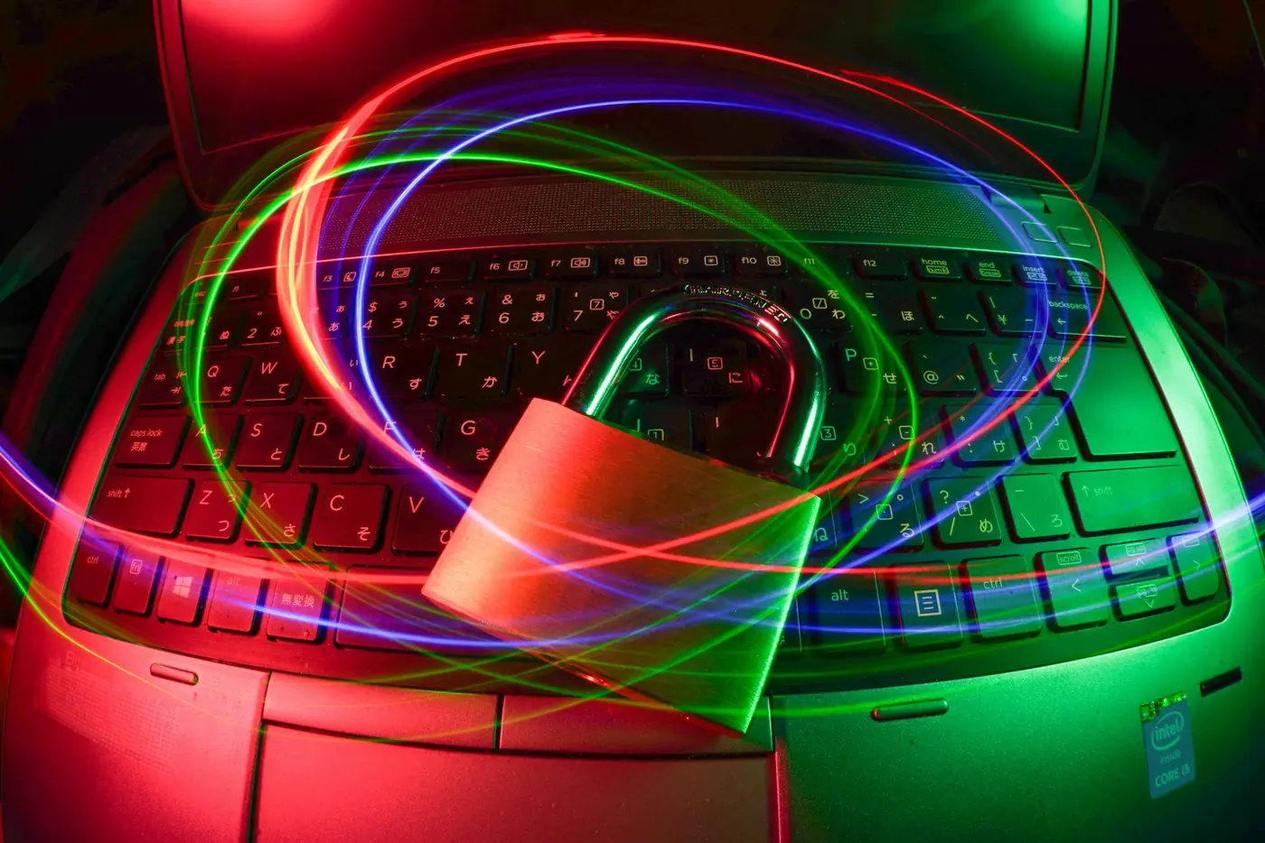 A padlock resting on a laptop keyboard with light trails